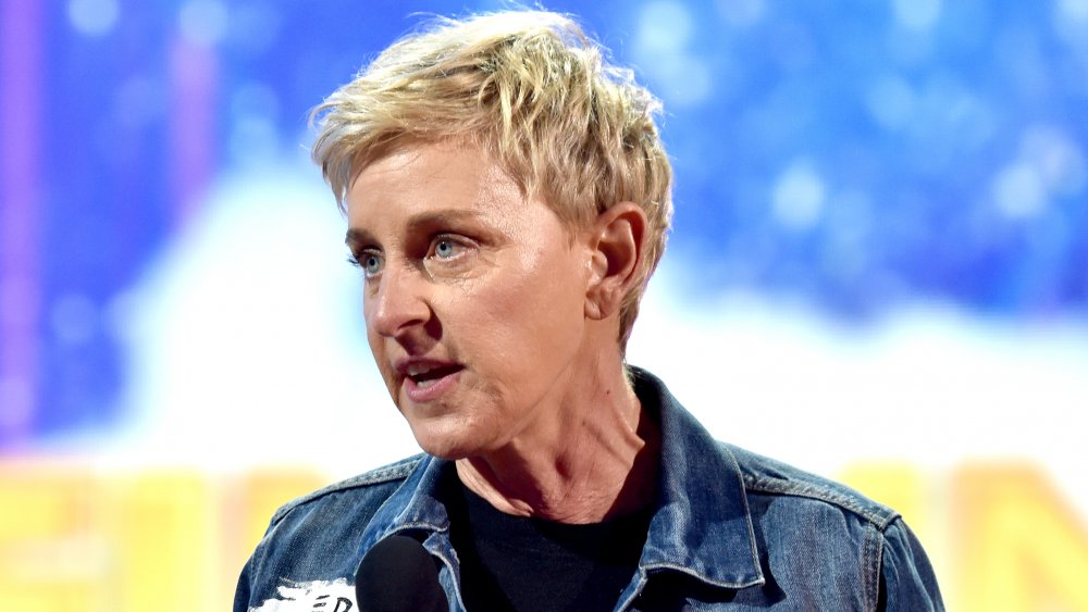 Ellen DeGeneres en una chaqueta de jean, hablando en un micrófono con una expresión intensa