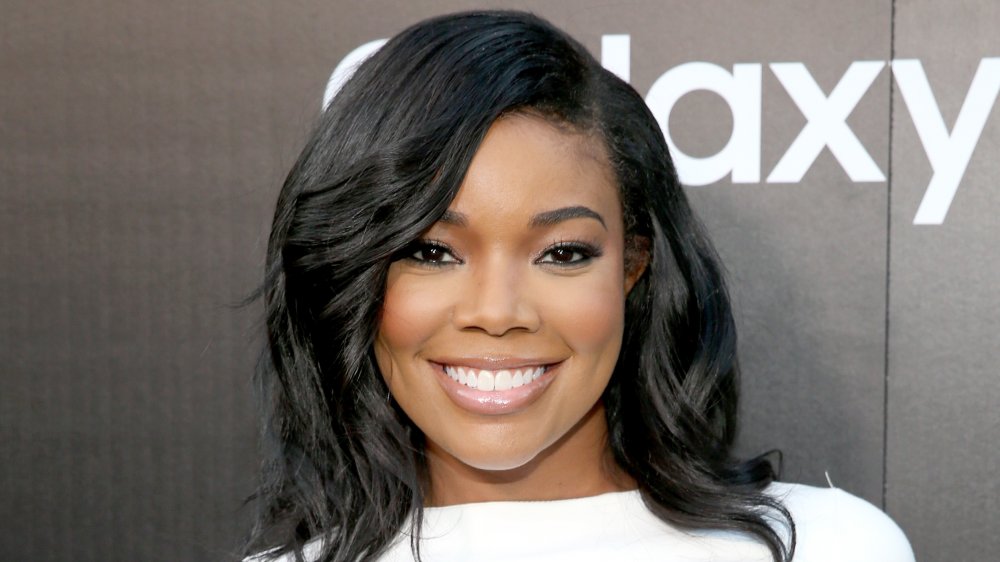 Gabrielle Union con un vestido blanco, sonriendo a lo grande en un evento de alfombra roja