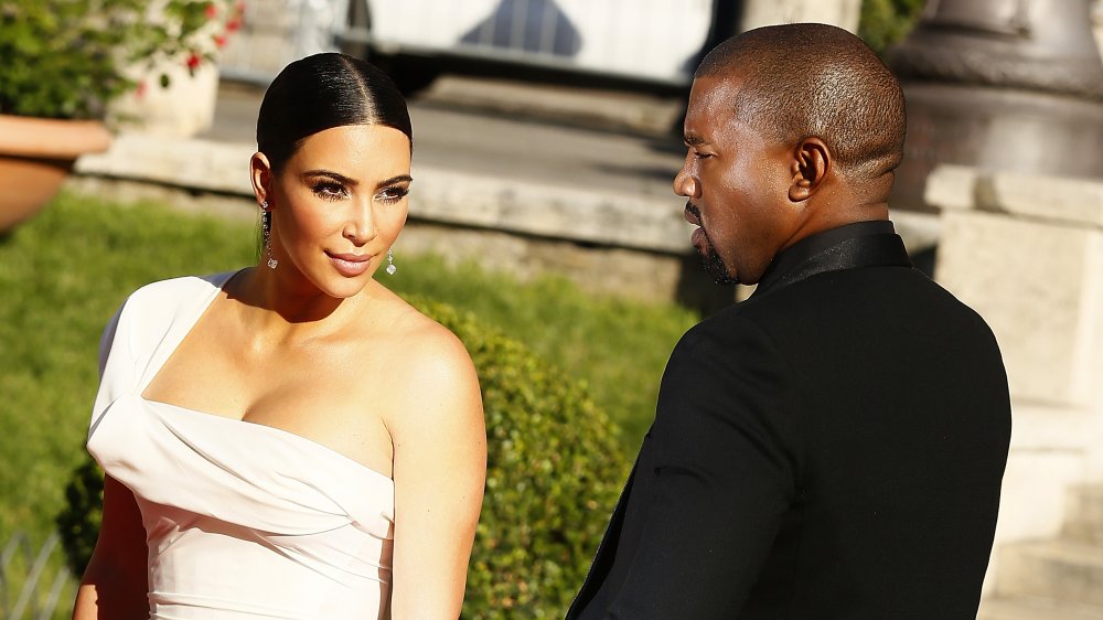 Kim Kardashian con un vestido blanco y Kanye West en un evento de alfombra roja