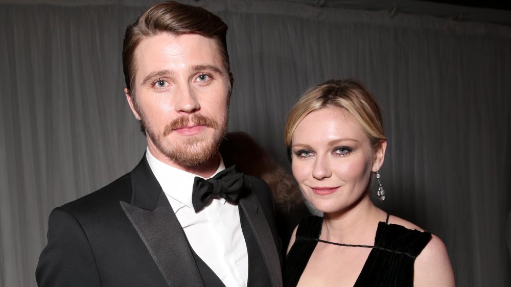 Garrett Hedlund y Kirsten Dunst, posando juntos, ambos en negro