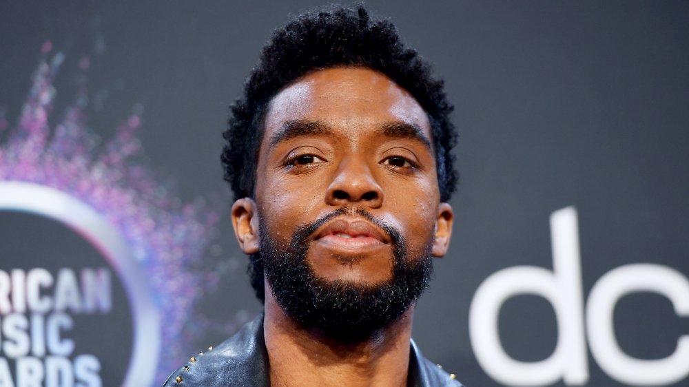 Chadwick Boseman con una chaqueta de cuero negro, posando en los AFA con una expresión neutra