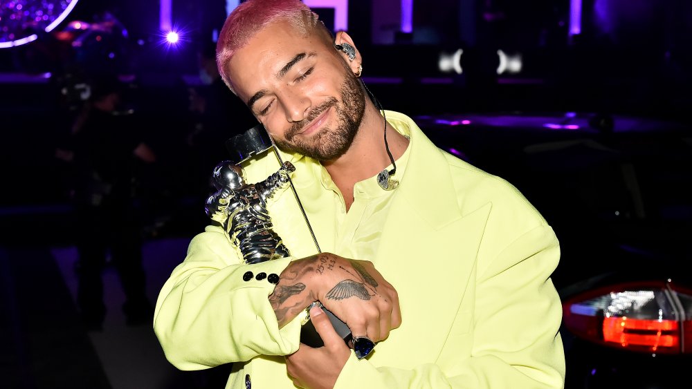 Maluma sosteniendo a un moonman de MTV