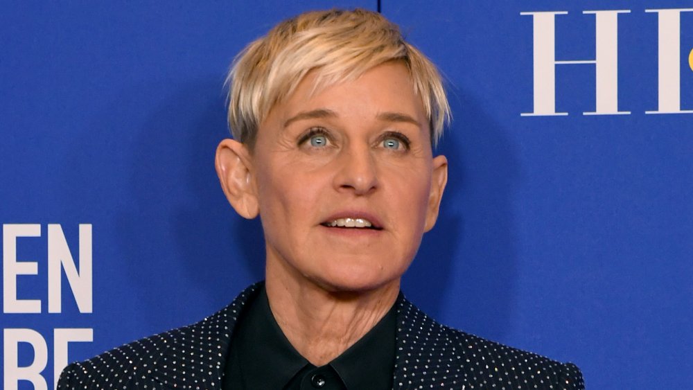 Ellen DeGeneres con un traje de lunares azul y camisa negra, posando con una expresión neutra en los Globos de Oro de 2020