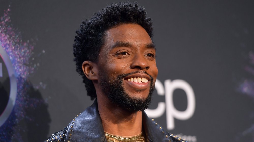 Chadwick Boseman sonriendo en la alfombra roja AMAs