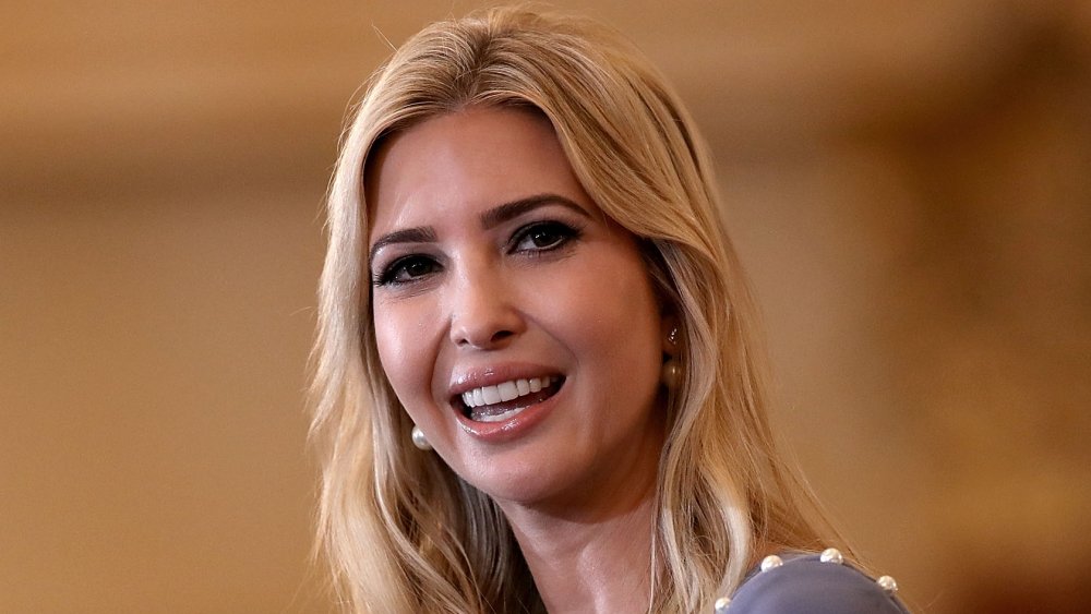 Ivanka Trump en una blusa de color púrpura claro, sonriendo mientras mira hacia un lado