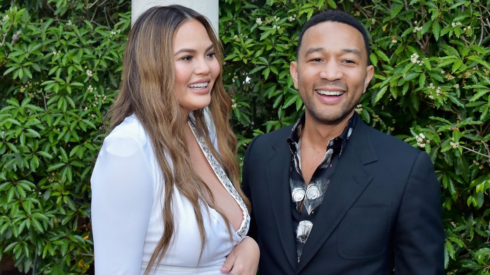 Chrissy Teigen y John Legend frente a la vegetación 