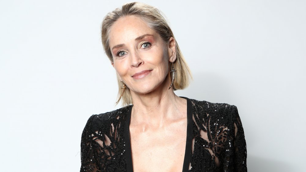 Sharon Stone con un traje negro, posando con una pequeña sonrisa