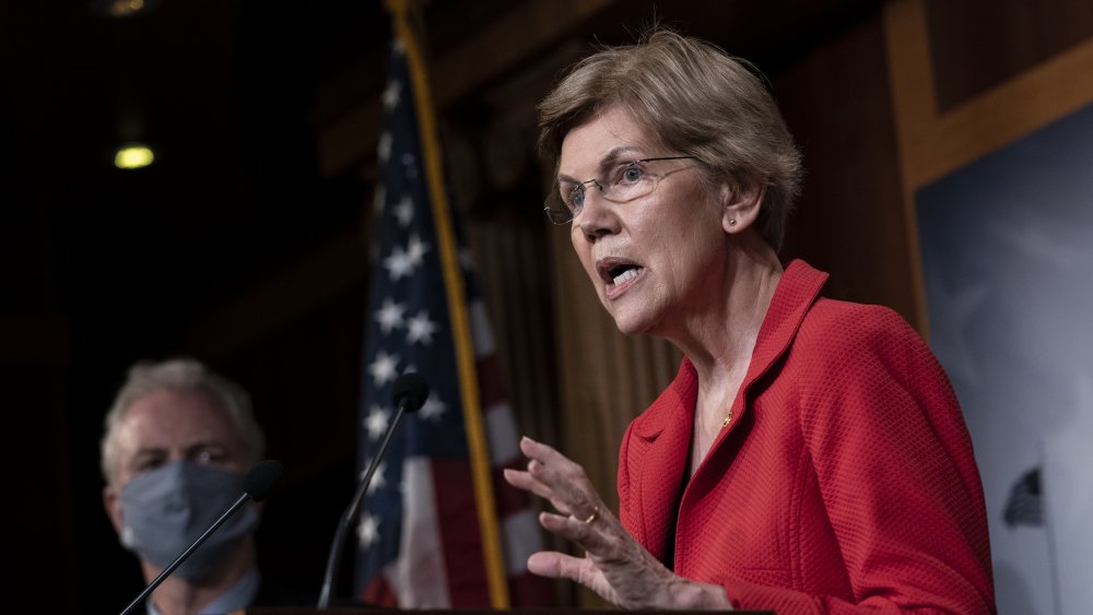 La senadora Elizabeth Warren en una chaqueta roja, hablando durante un evento político