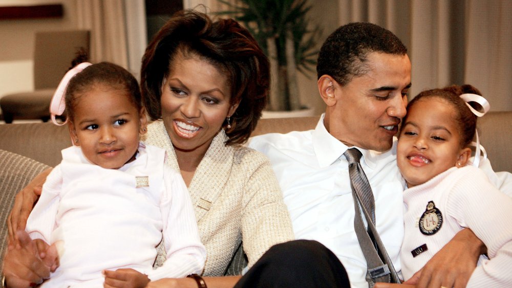 Sasha Obama, Michelle Obama, Barack Obama y Malia Obama posando para una foto de familia en una habitación de hotel en Chicago en 2004 