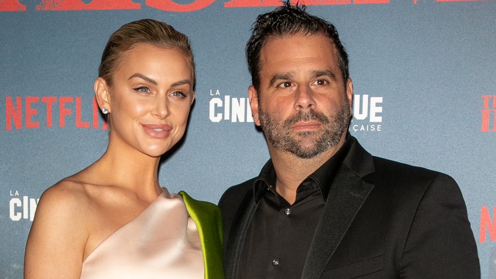 Lala Kent con un vestido rosa, Randall Emmett en traje negro, asistiendo a un estreno de Netflix