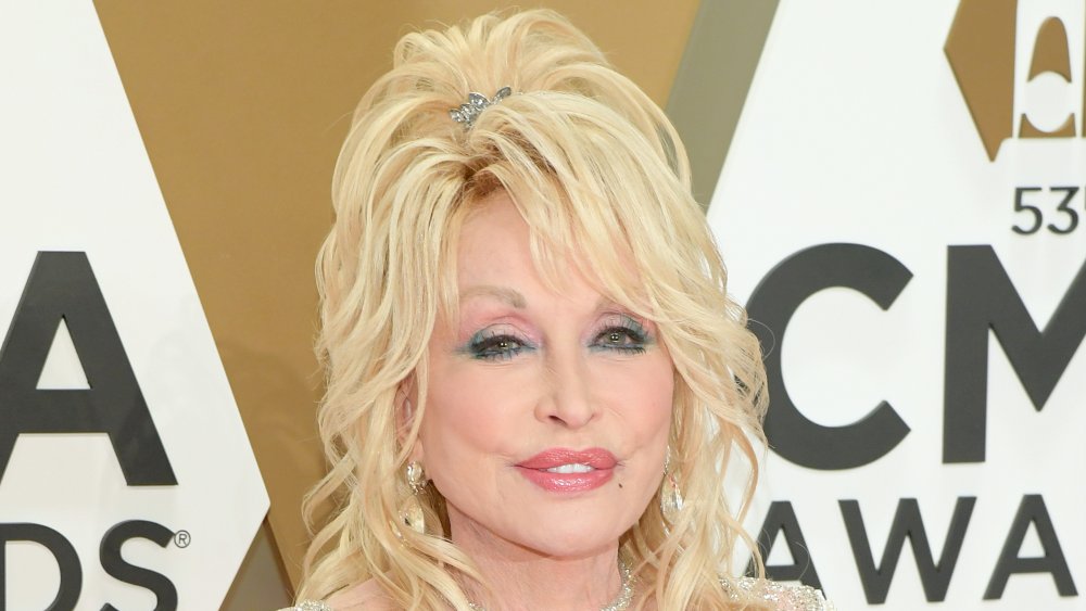 Dolly Parton con un vestido blanco brillante, posando en los Premios CMA