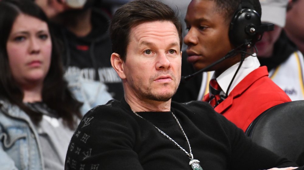 Mark Wahlberg con camisa negra, sentado