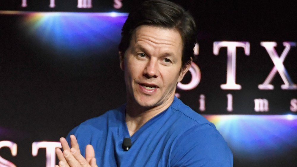 Mark Wahlberg con una camisa azul, hablando con una multitud