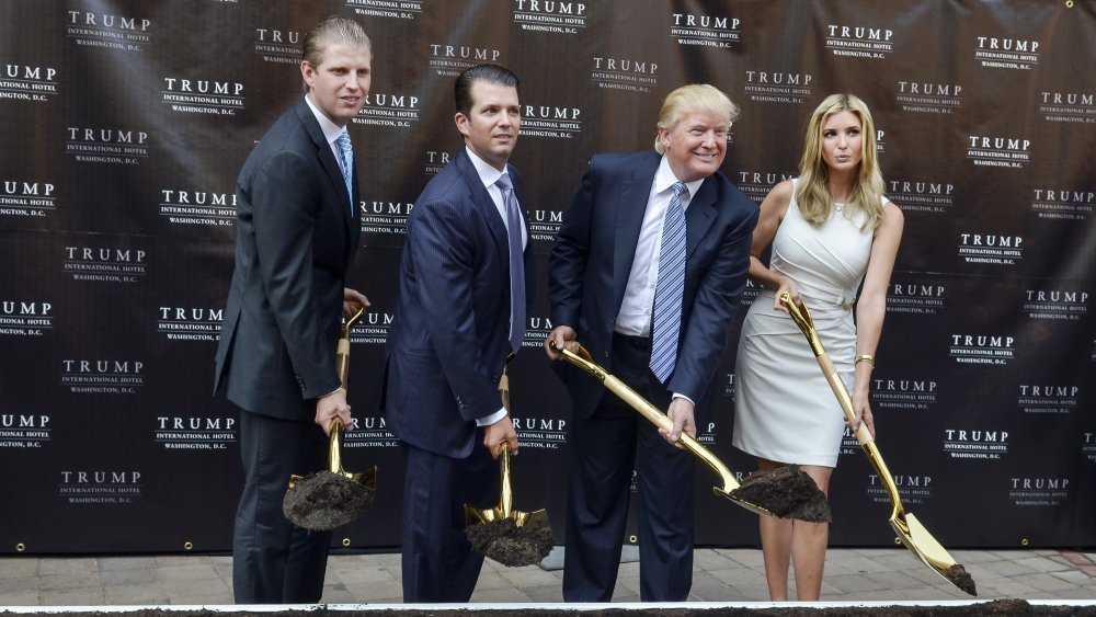 Eric Trump, Donald Trump Jr., Donald Trump e Ivanka Trump sostienen palas de oro con tierra