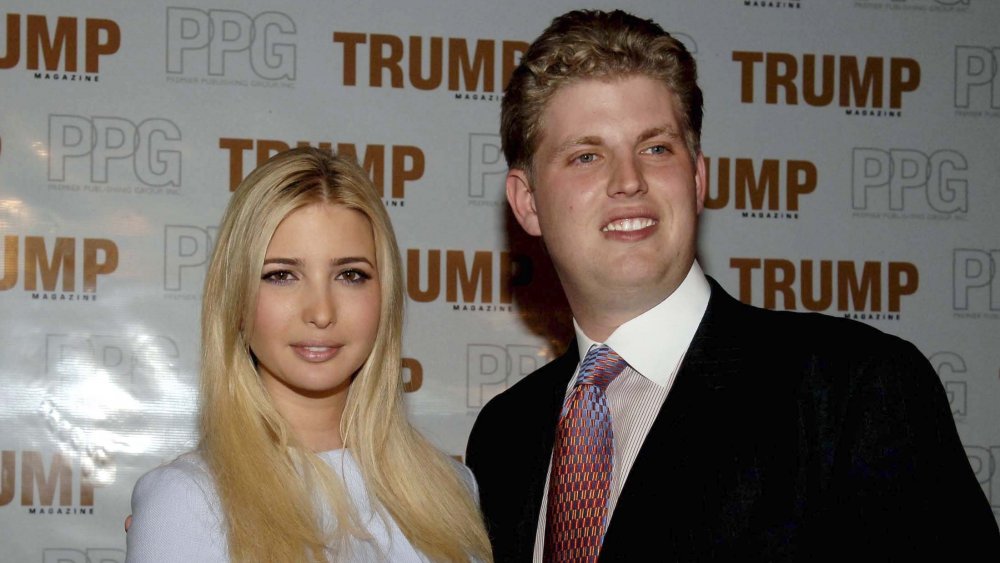 Ivanka Trump y Eric Trump frente a un muro promocional de Trump