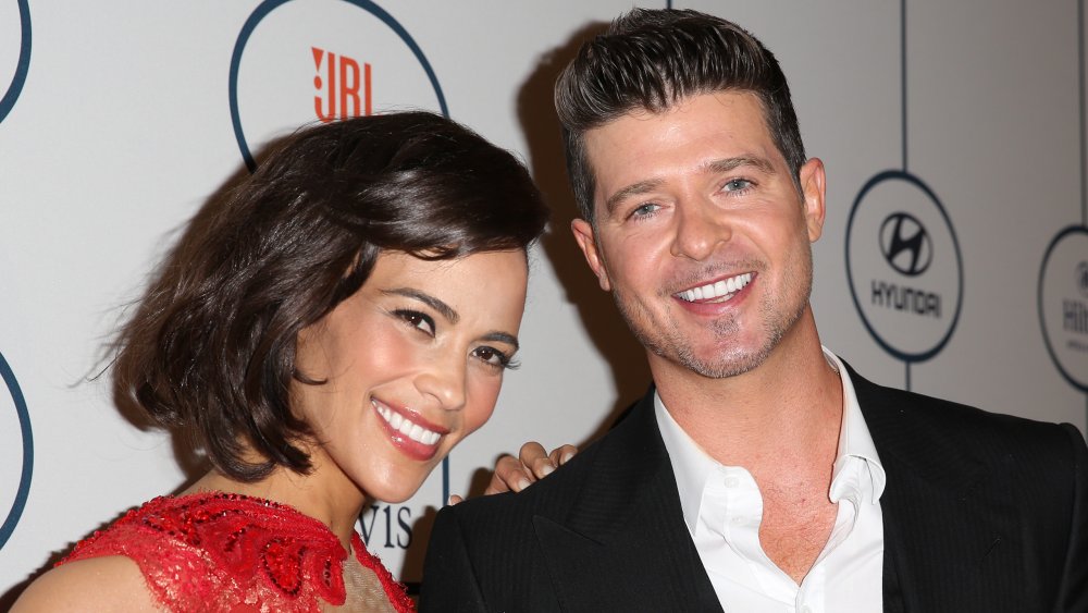 Paula Patton con la mano en el hombro de Robin Thicke