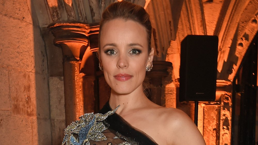 Rachel McAdams en un brillante vestido plateado, azul y negro, posando con una expresión neutra