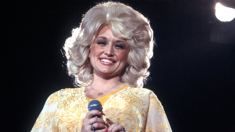 Young Dolly Parton sonriendo en el escenario