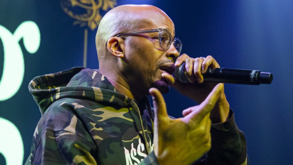 Warren G en el escenario, rapeando, con gafas