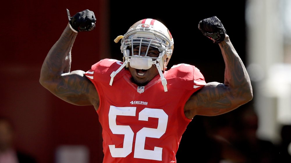 Patrick Willis gritando con los brazos en parados mientras celebra en el campo