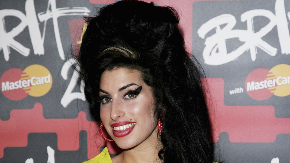 Amy Winehouse con su característico pelo de colmena y delineador de ojos exagerado 