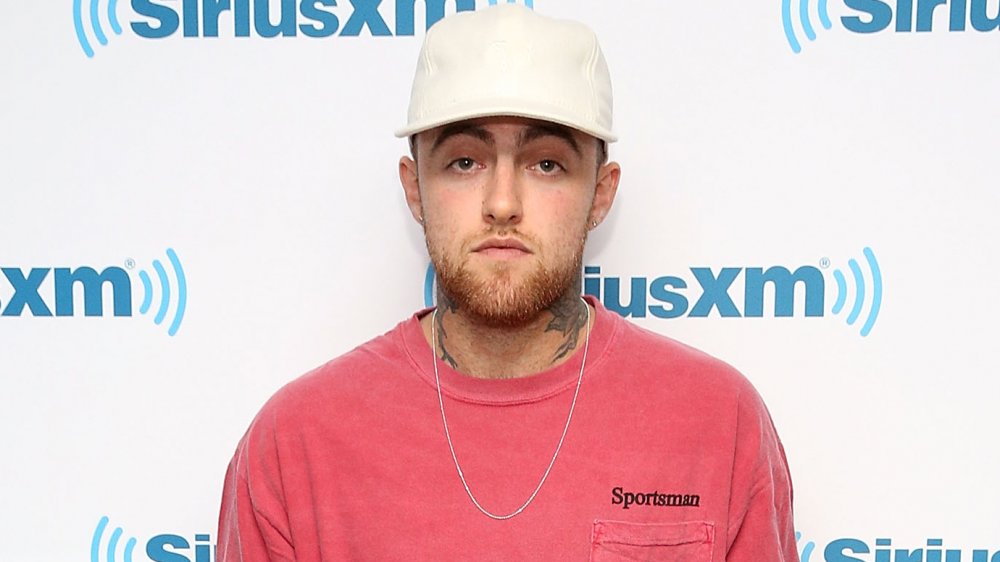 Mac Miller en una camiseta rosa y gorra de béisbol blanca