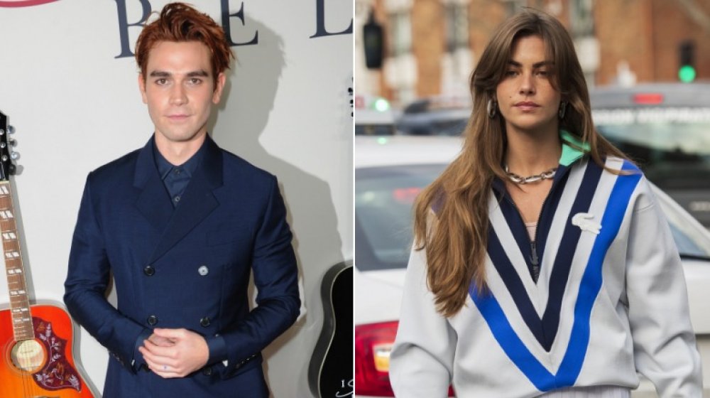 KJ Apa en traje azul marino y Clara Berry con suéter Lacoste