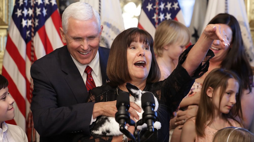 Karen Pence sosteniendo a su conejito mascota en un podio, Mike Pence riendo