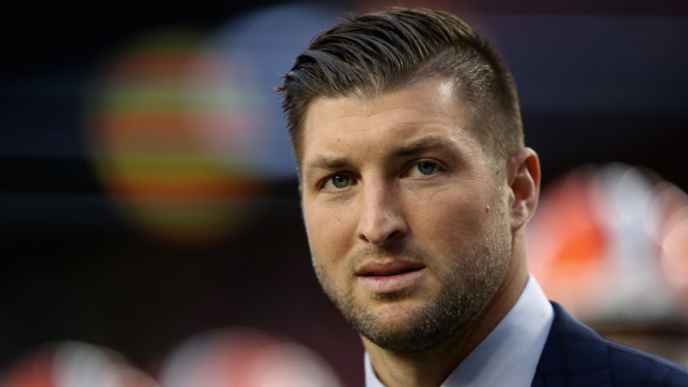 Tim Tebow en traje, con una expresión seria