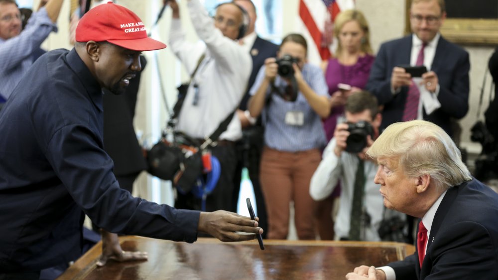 Kanye West mostrando a Donald Trump su teléfono