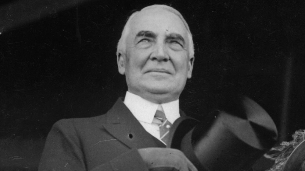 Warren Harding sosteniendo su sombrero y mirando fuera de la cámara