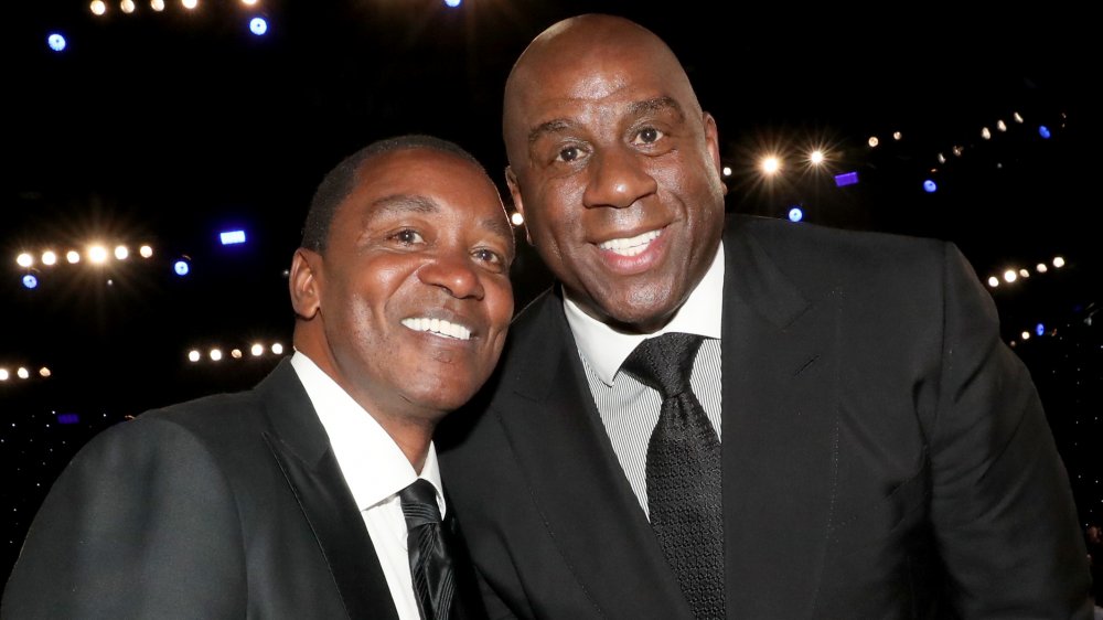 Isiah Thomas y Magic Johnson en trajes, sonriendo