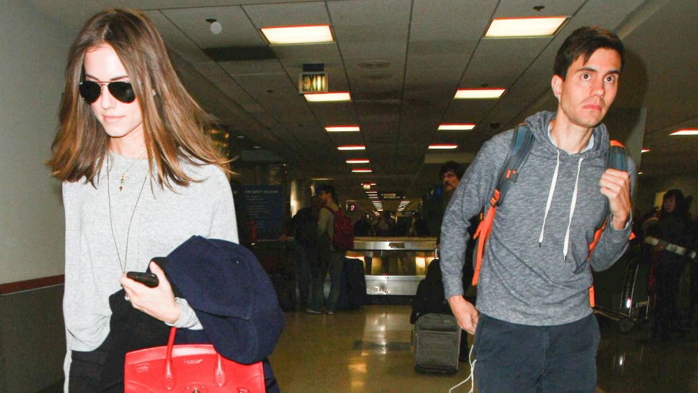 Allison Williams y Ricky Van Veen saliendo de un aeropuerto