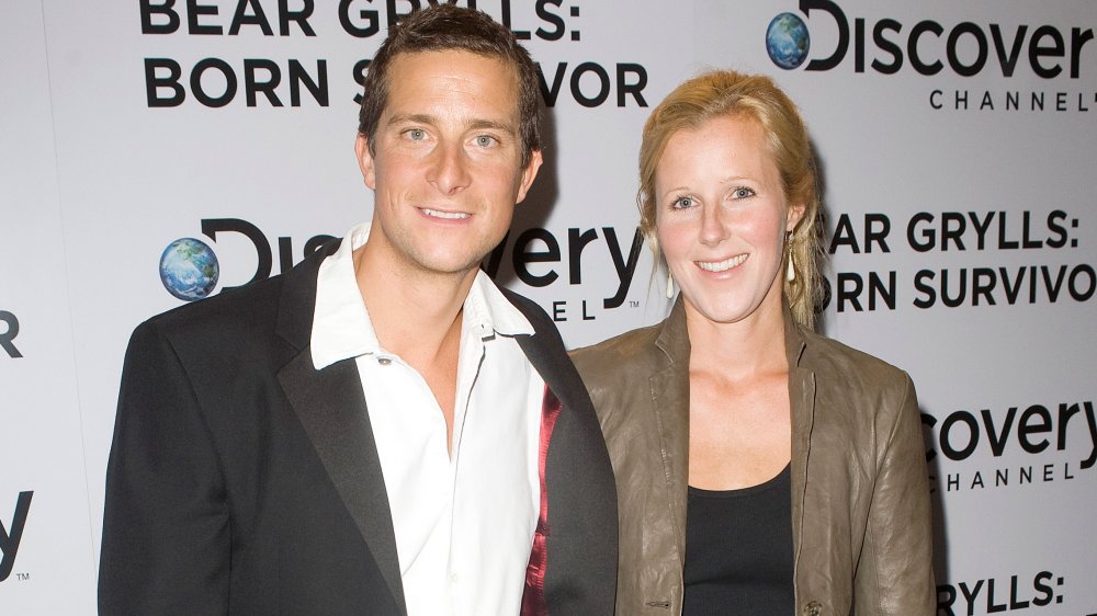 Bear Grylls y Shara Grylls frente al muro promocional Discovery