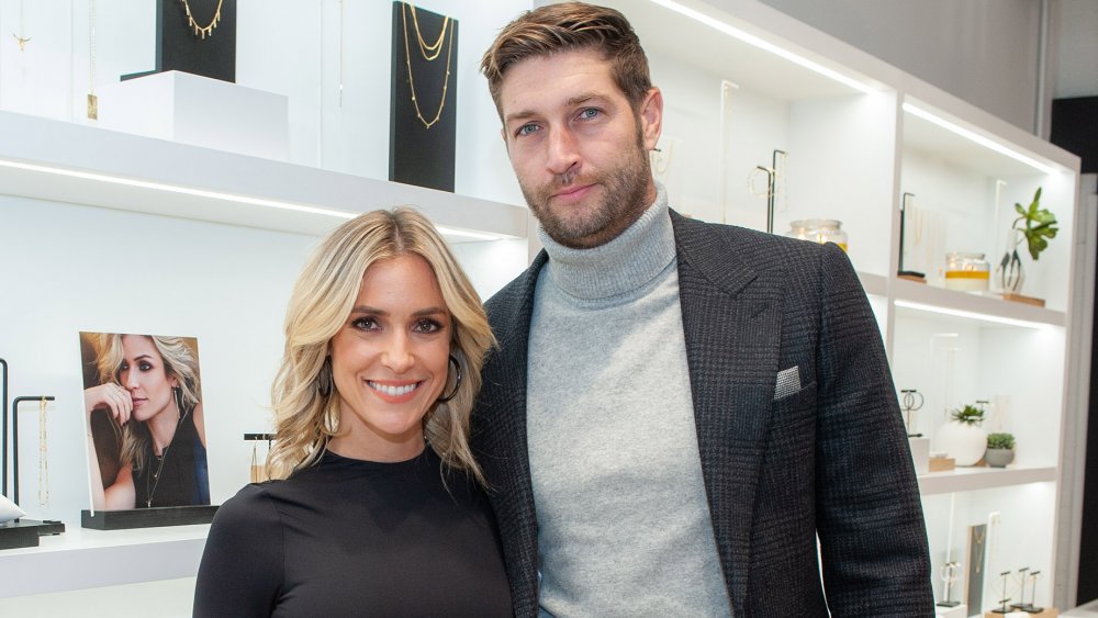 Kristin Cavallari y Jay Cutler, sonriendo mientras posa de brazo en brazo en una tienda