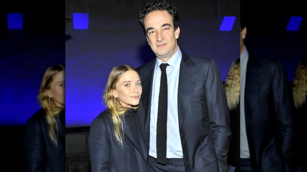 Mary-Kate Olsen y Pierre Olivier Sarkozy, posando brazo en brazo con expresiones serias