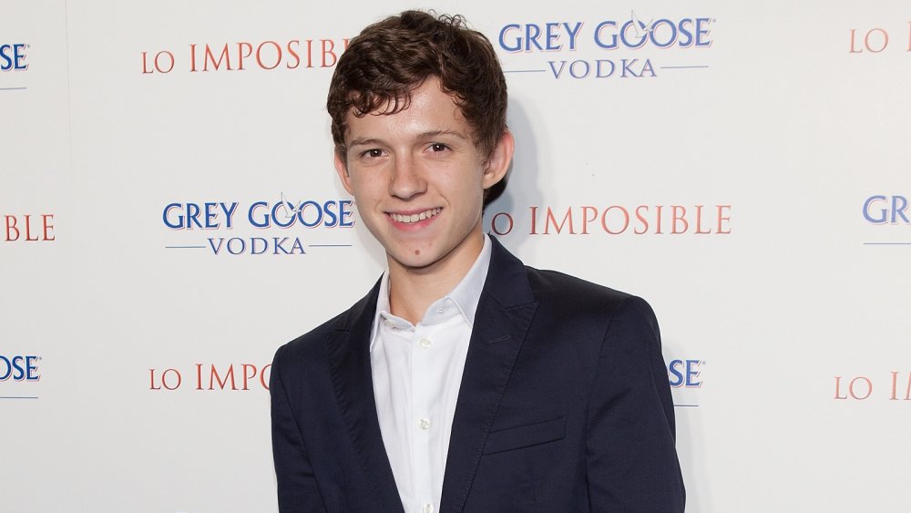 Un adolescente Tom Holland sonriendo en el estreno de The Impossible