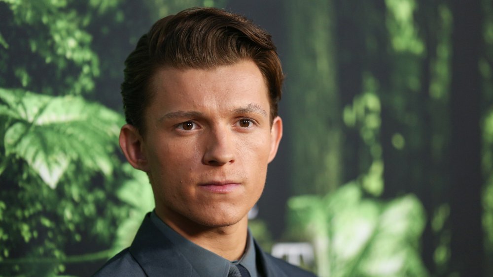 Tom Holland posando con una expresión seria en el estreno de La Ciudad Perdida de Z