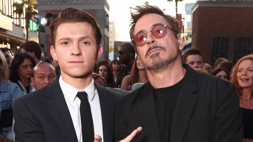 Tom Holland y Robert Downey Jr., posando en un estreno de película con expresiones serias