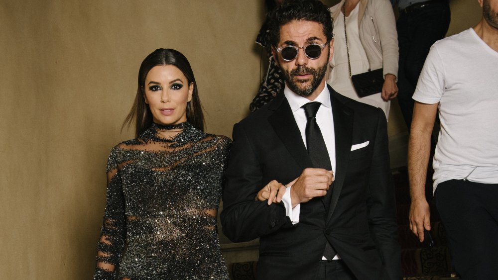 Eva Longoria con un vestido negro y brillante y José Bastón en traje y gafas de sol