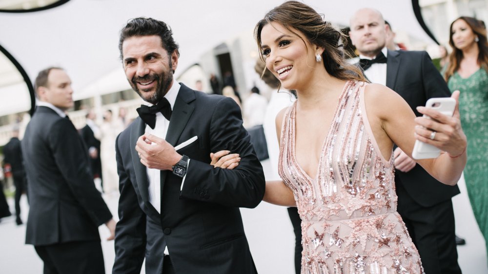 José Bastón y Eva Longoria caminando juntos en un evento formal