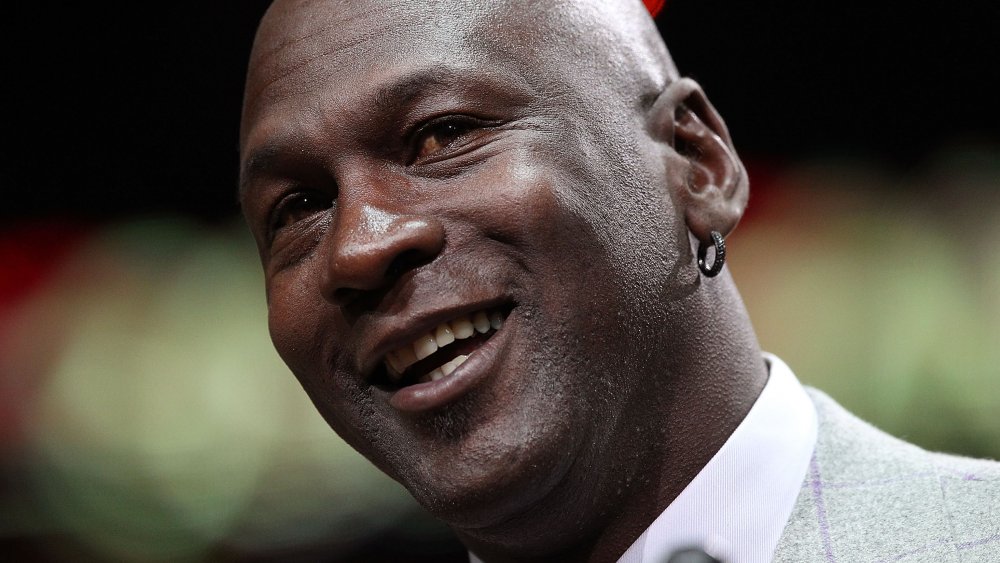 Michael Jordan sonriendo mientras inclina la cabeza hacia un lado