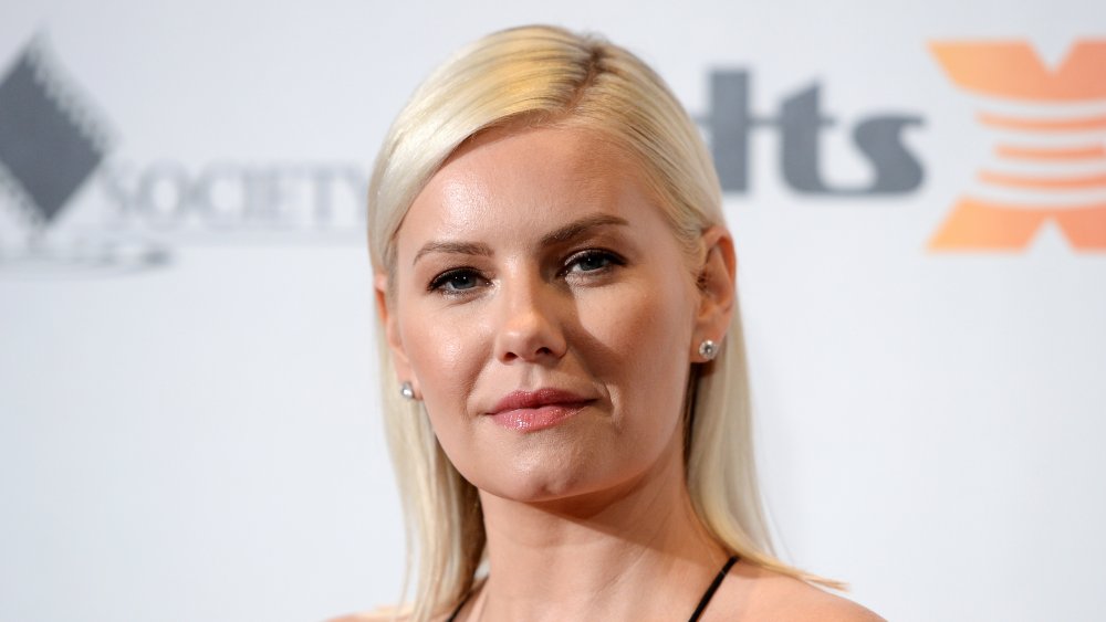 Elisha Cuthbert sonriendo, cabello peinado hacia atrás