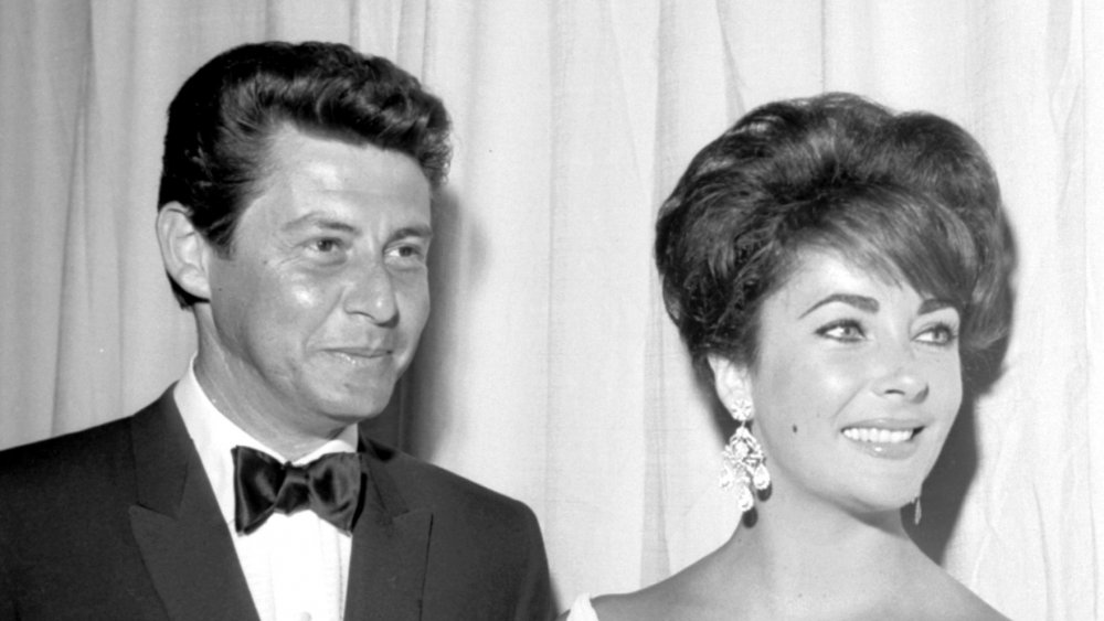 La actriz Elizabeth Taylor asiste a un evento con su esposo, el animador Eddie Fisher, alrededor de 1960.