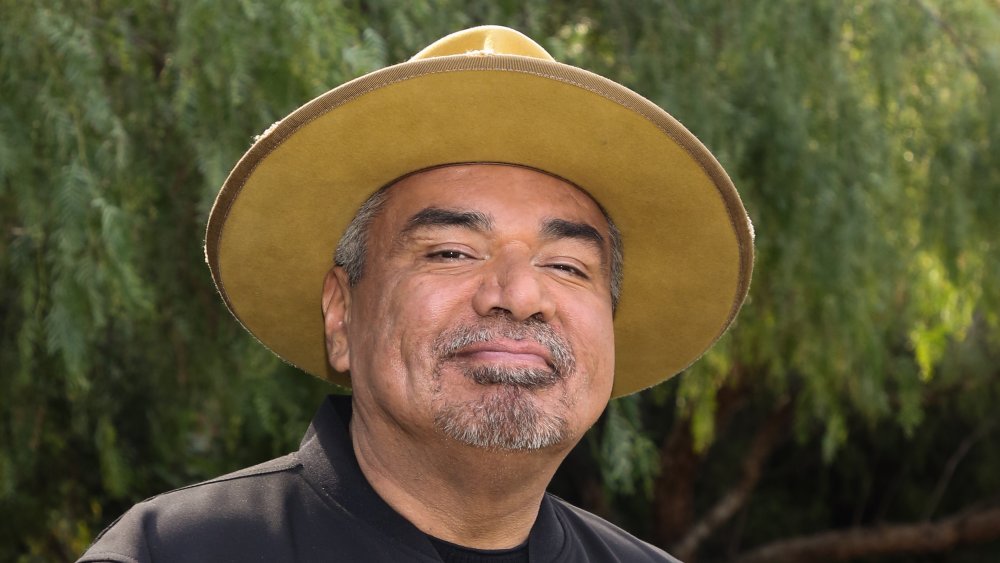 George Lopez parado afuera y sonriendo