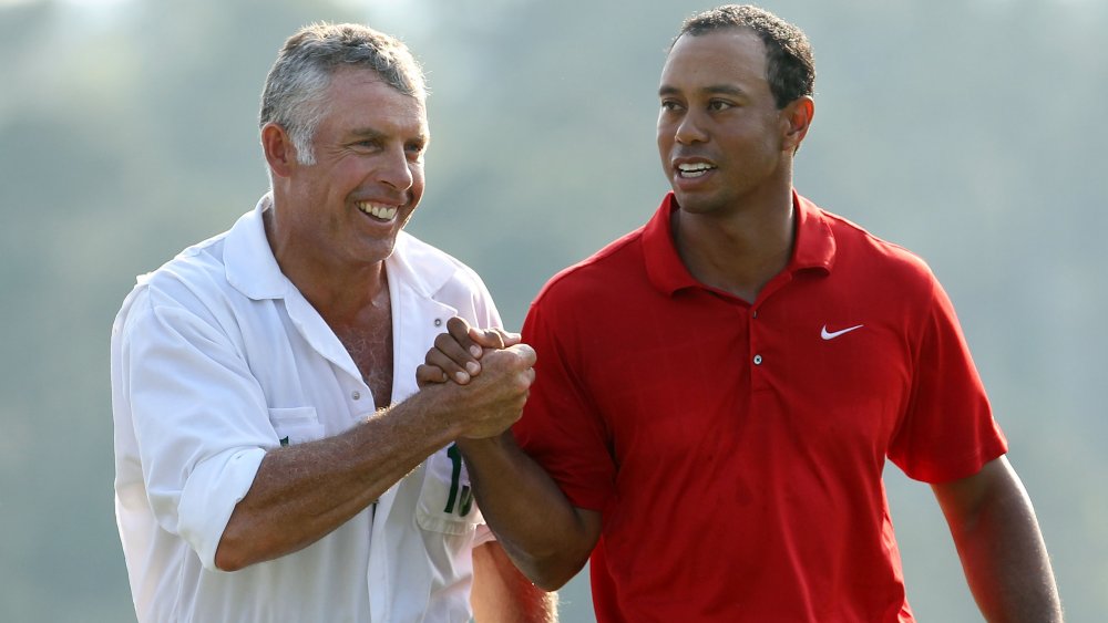 Steve Williams y Tiger Woods se dan la mano y sonríen en el campo de golf