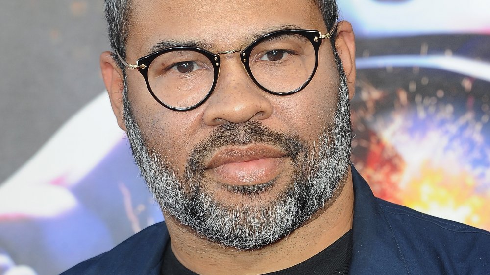 Jordan Peele con la cara seria en la alfombra roja