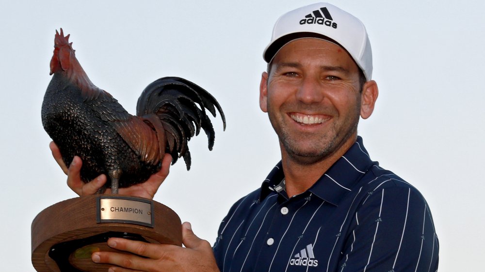 Sergia García sonriendo y sosteniendo un trofeo de pollo