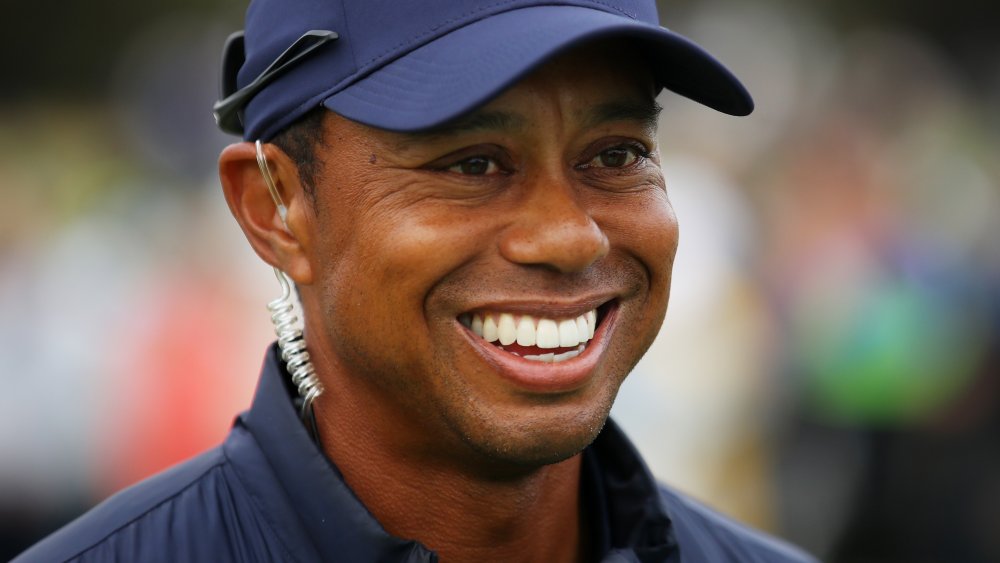 Tiger Woods sonriendo en el campo de golf