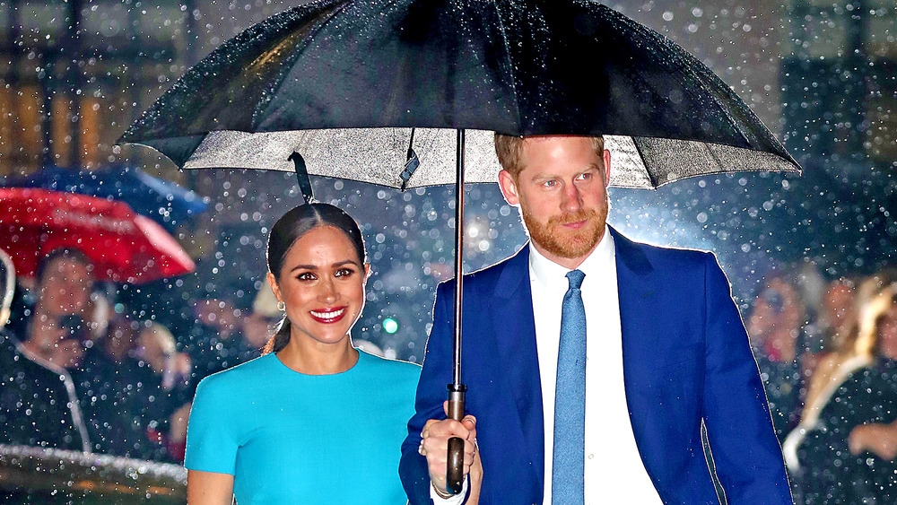 Meghan Markle con el príncipe Harry bajo la lluvia